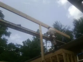 Carpenter setting a ridge beam over a new addition frame — Ice Dam Removal by Roofing Brothers in Lennon