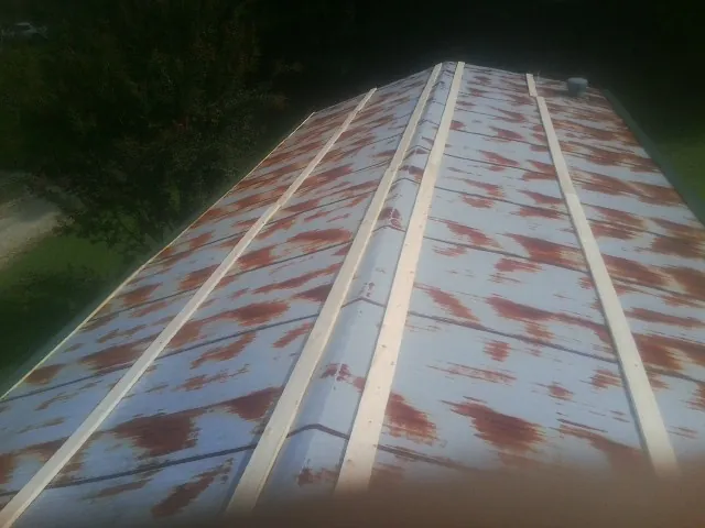 Rusted metal roof panels with new wood purlins before replacement — Storm Damage Roof Repair in Lennon by Roofing Brothers